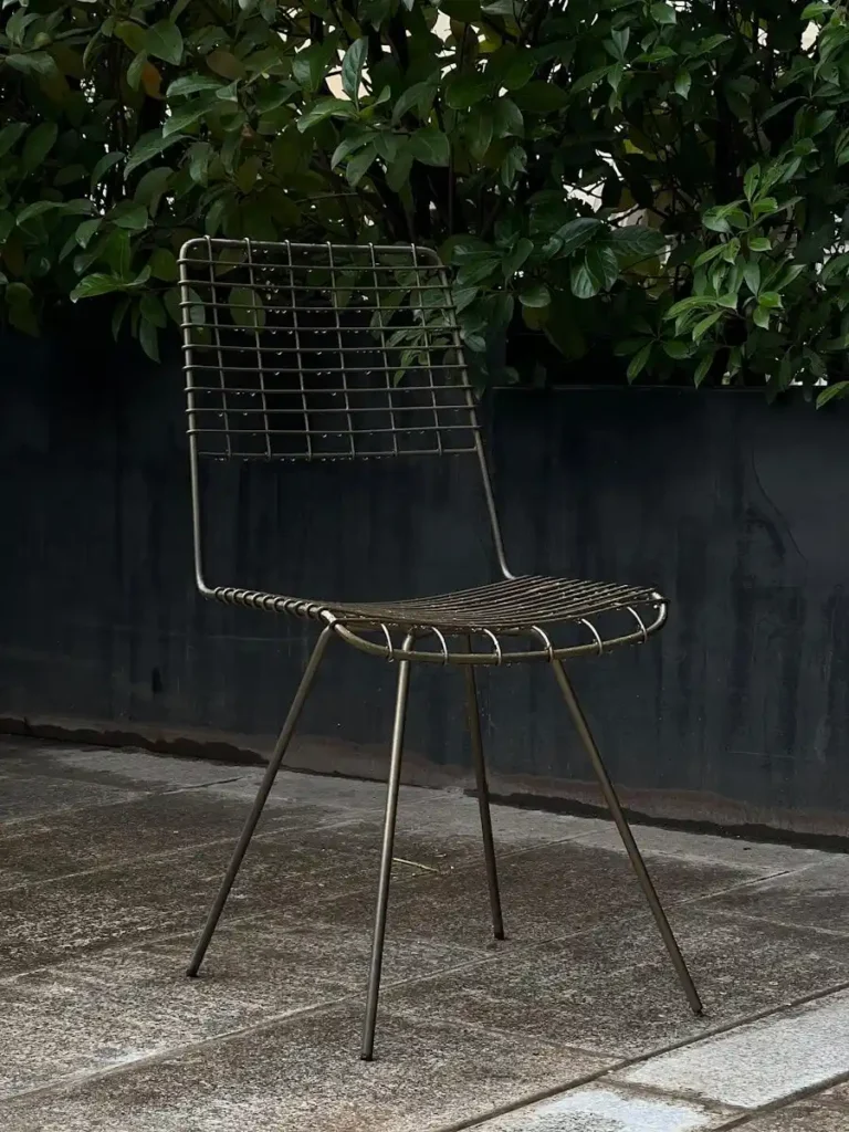 a metal chair sitting on top of a sidewalk